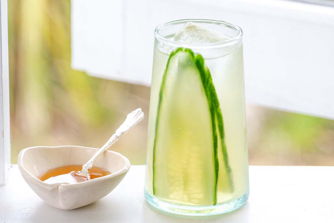 glass of green tea and honey by window