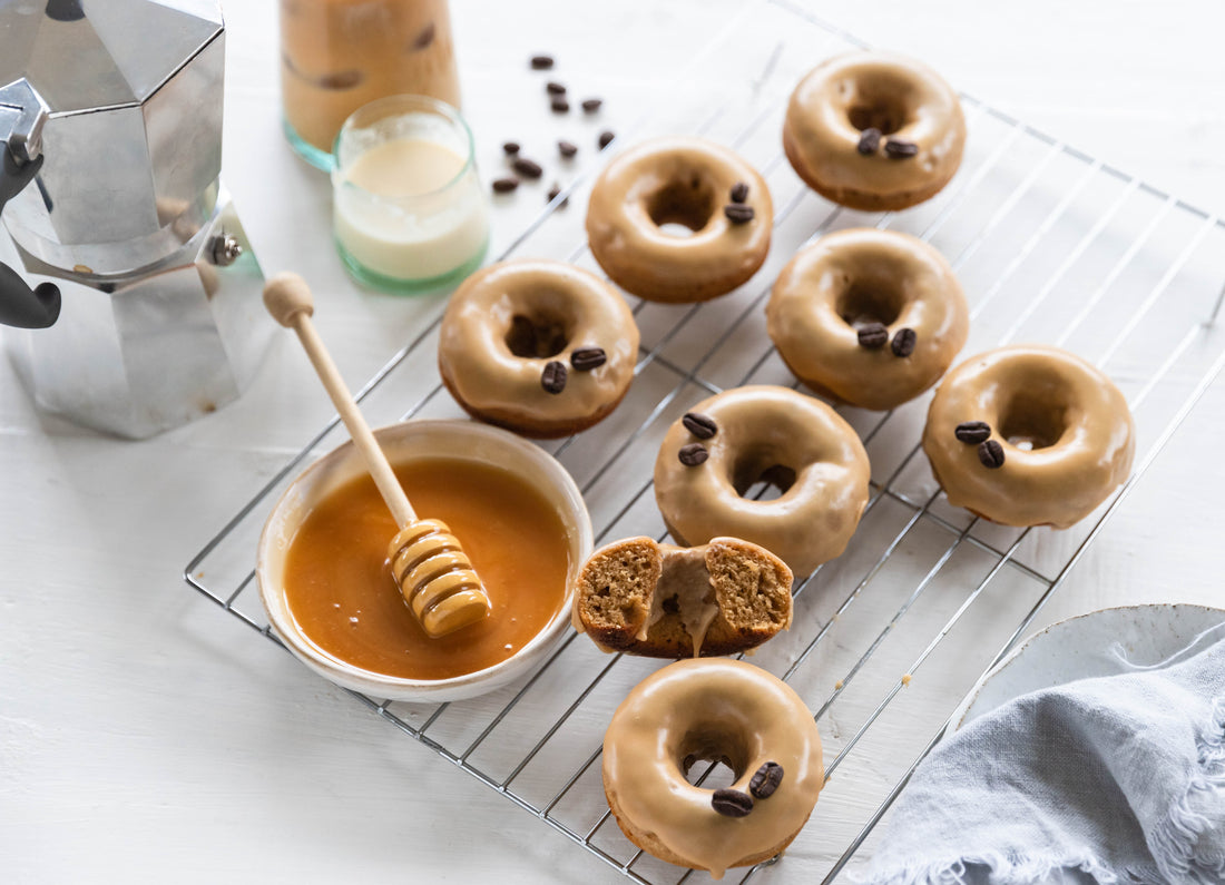 baked-coffee-glazed-donuts-on-silver-tray-with-bowl-of-honey-and-dipper