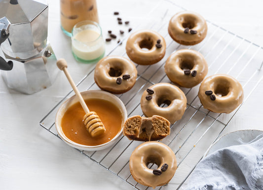 baked-coffee-glazed-donuts-on-silver-tray-with-bowl-of-honey-and-dipper