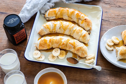 Tray of bananas covered in pastry and honey